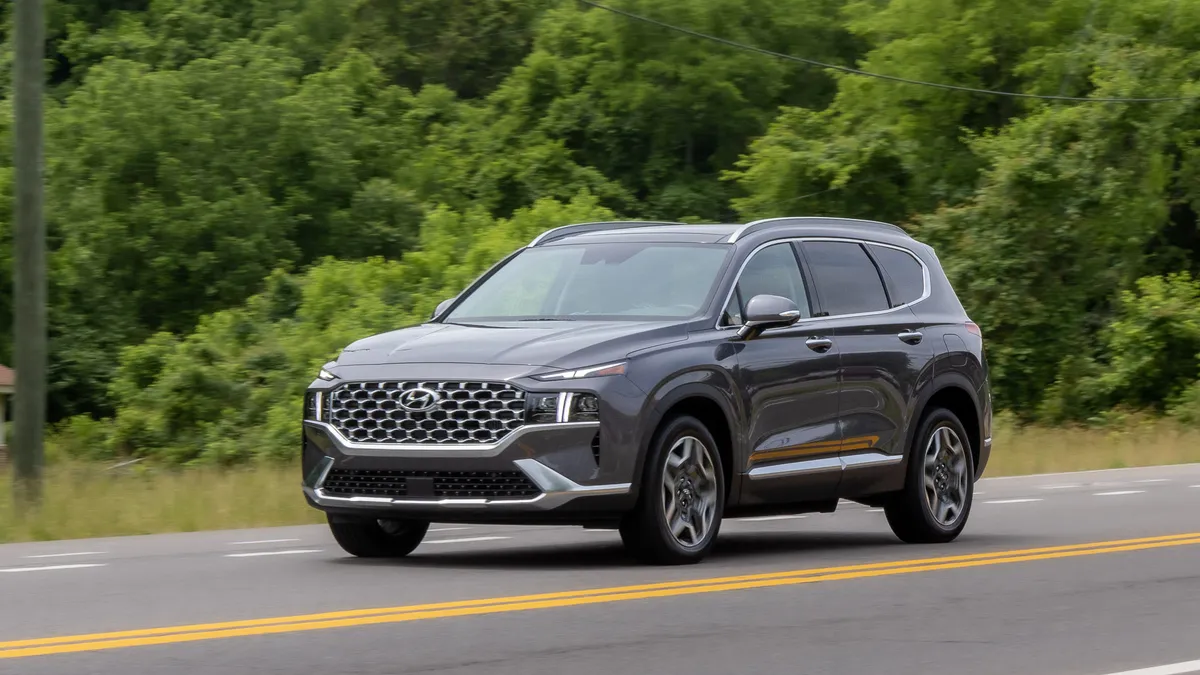 A 2023 Hyundai Santa Fe Plug-In Hybrid SUV on the road with tress in the background.