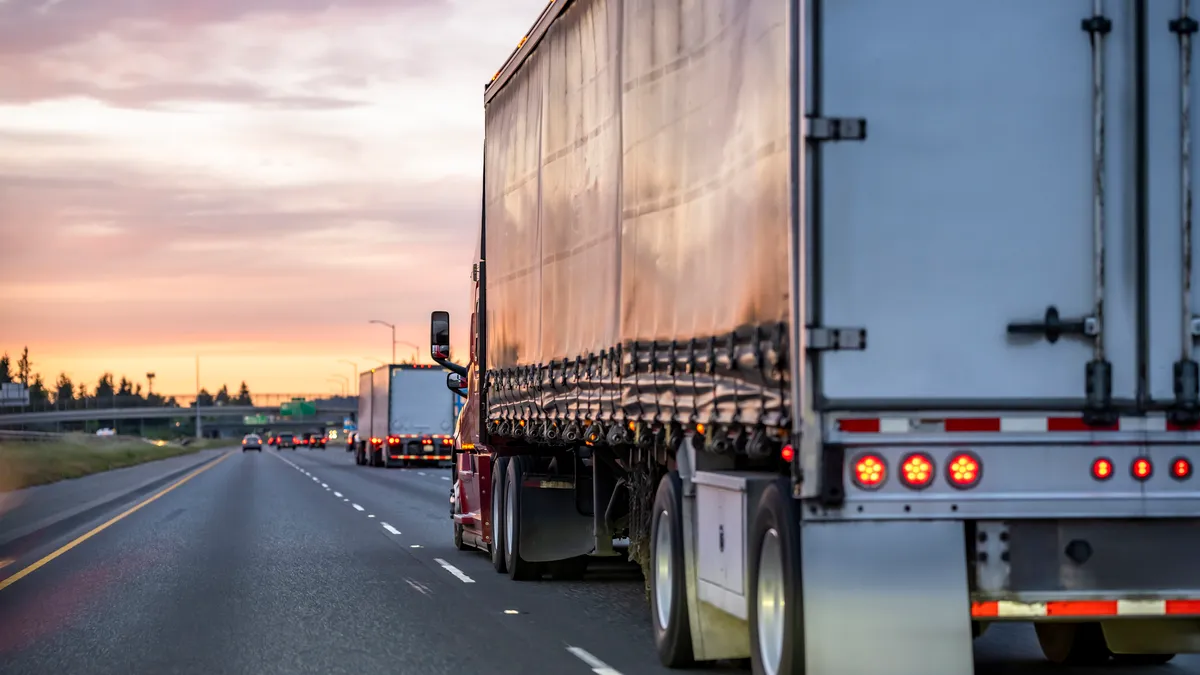 Trucks travel on a highway.