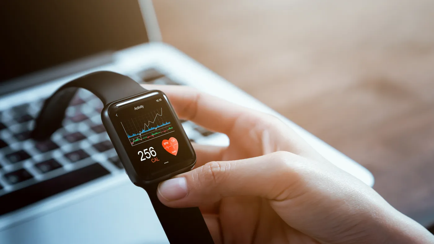 Close up of hand touching smartwatch with health app on the screen.