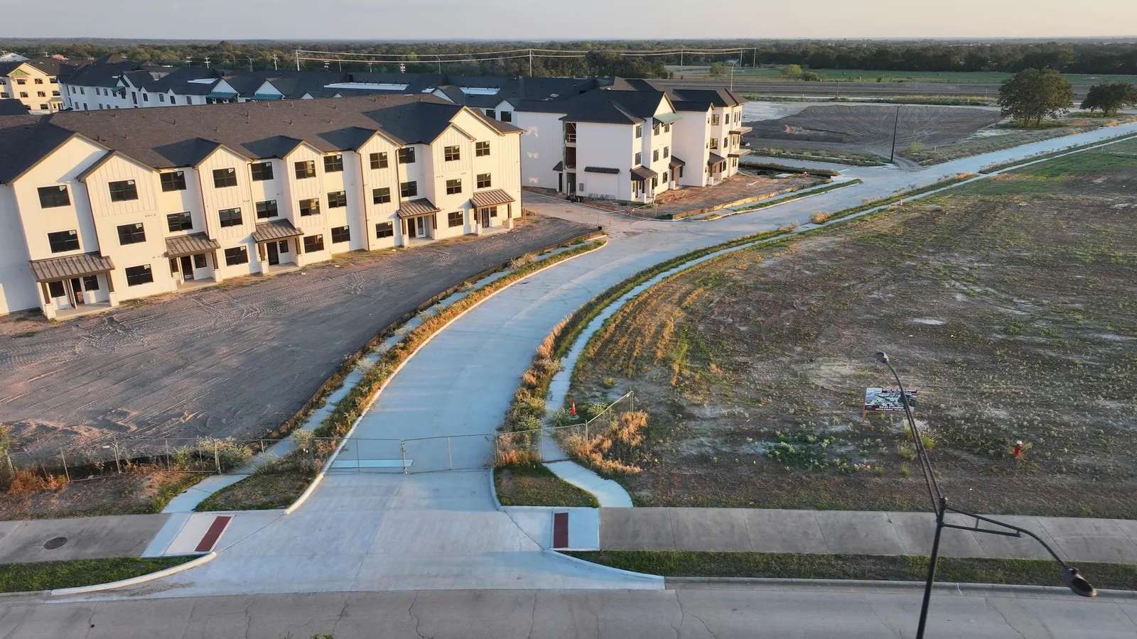 A white apartment complex is seen under construction.