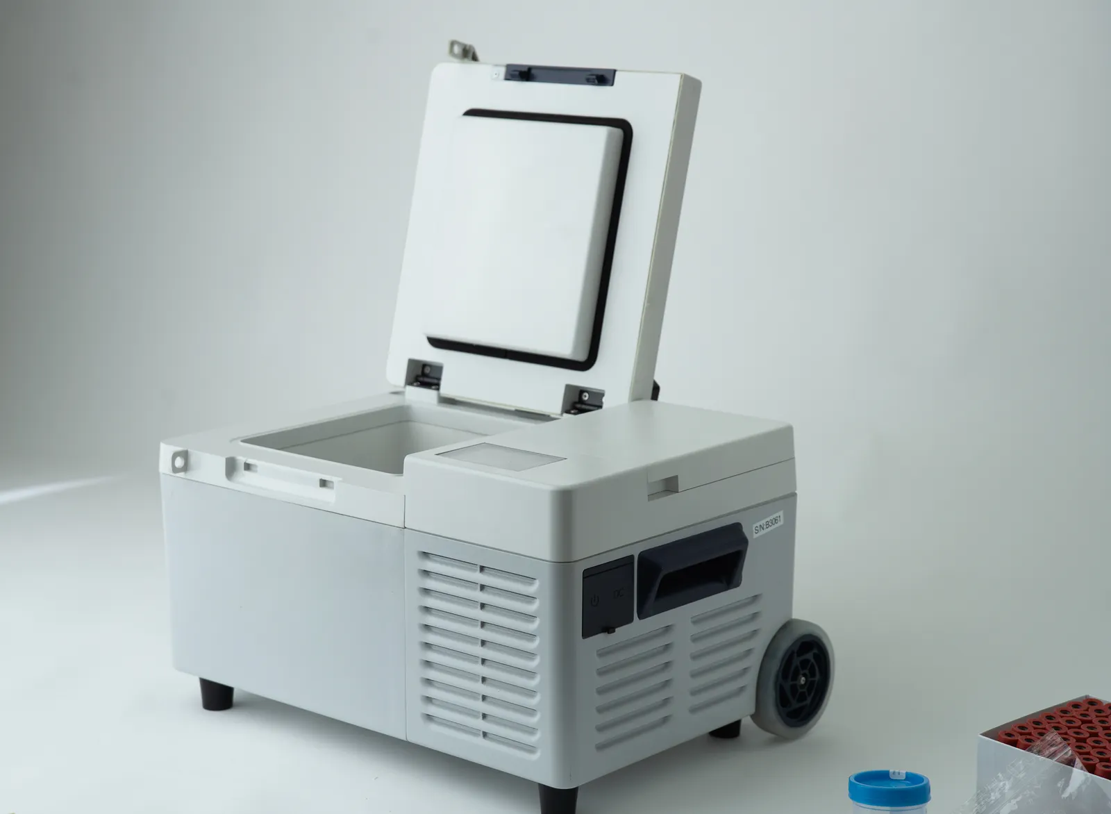 A battery-operated cooler with an open lid.