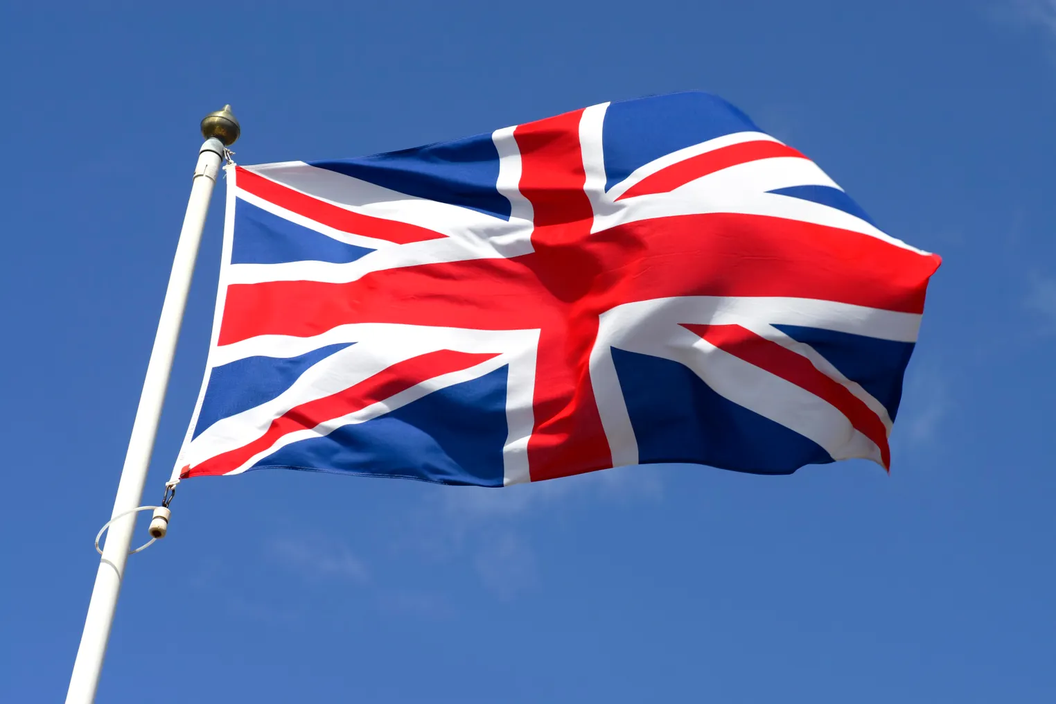 A union jack flag waves in the wind