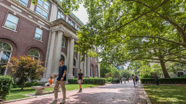 Students walk on an outside pathway next to a Columbia University building.