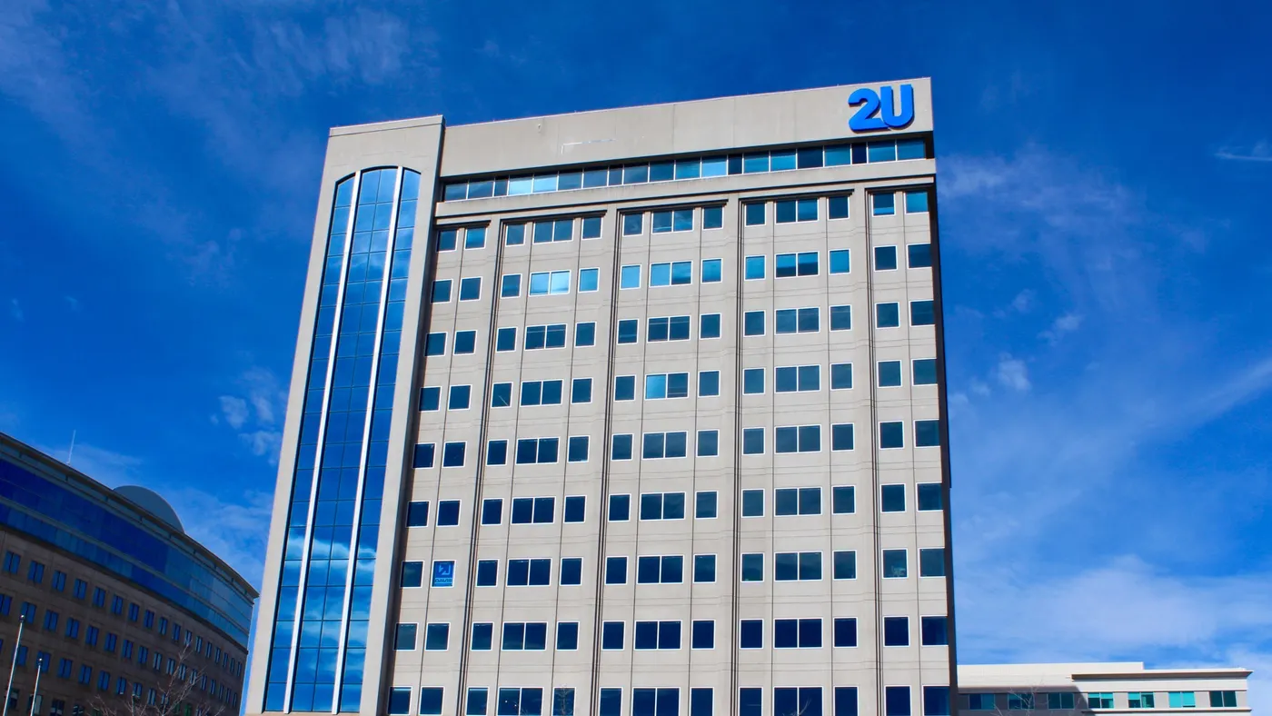 A building is topped by blue letters reading 2U.