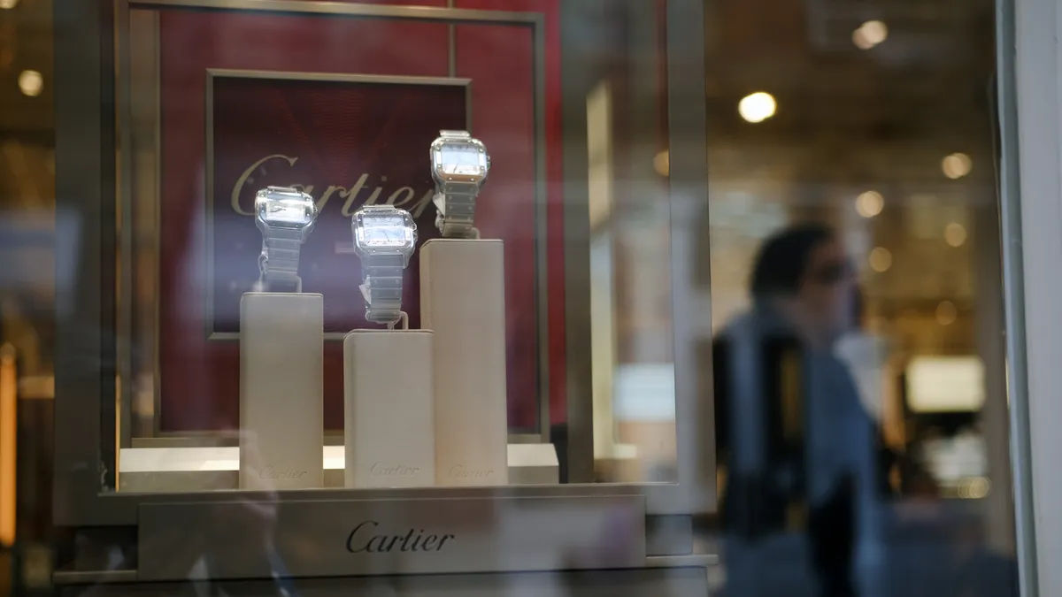 Shoppers walk past a Cartier store in SoHo, New York City.