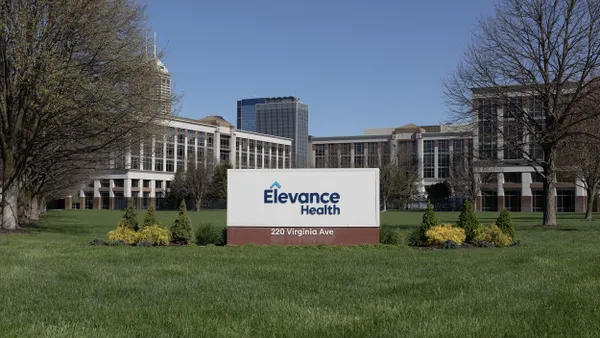 A sign reading 'Elevance Health 220 Virginia Ave' in front of a large office complex on a clear day.