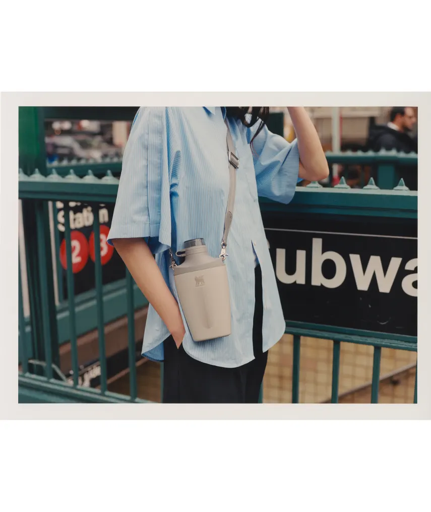 A person wearing a cross-body water bottle.
