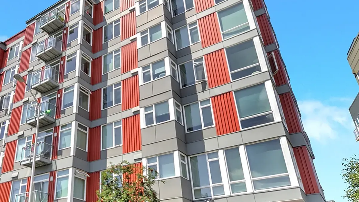Ground level view of red mid-rise apartments