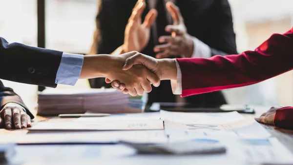 Business cooperation at a meeting of business people. Business partners shaking hands in a meeting.