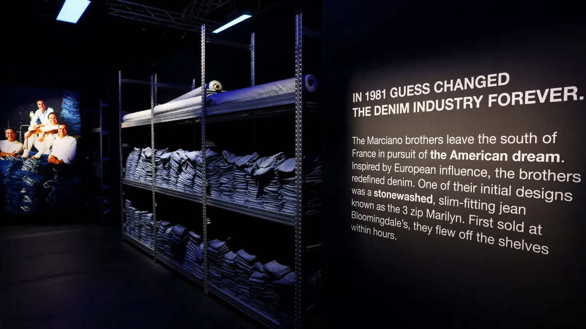 A display features signage reading "In 1981 Guess changed the denim industry forever" and a display of denim jeans.