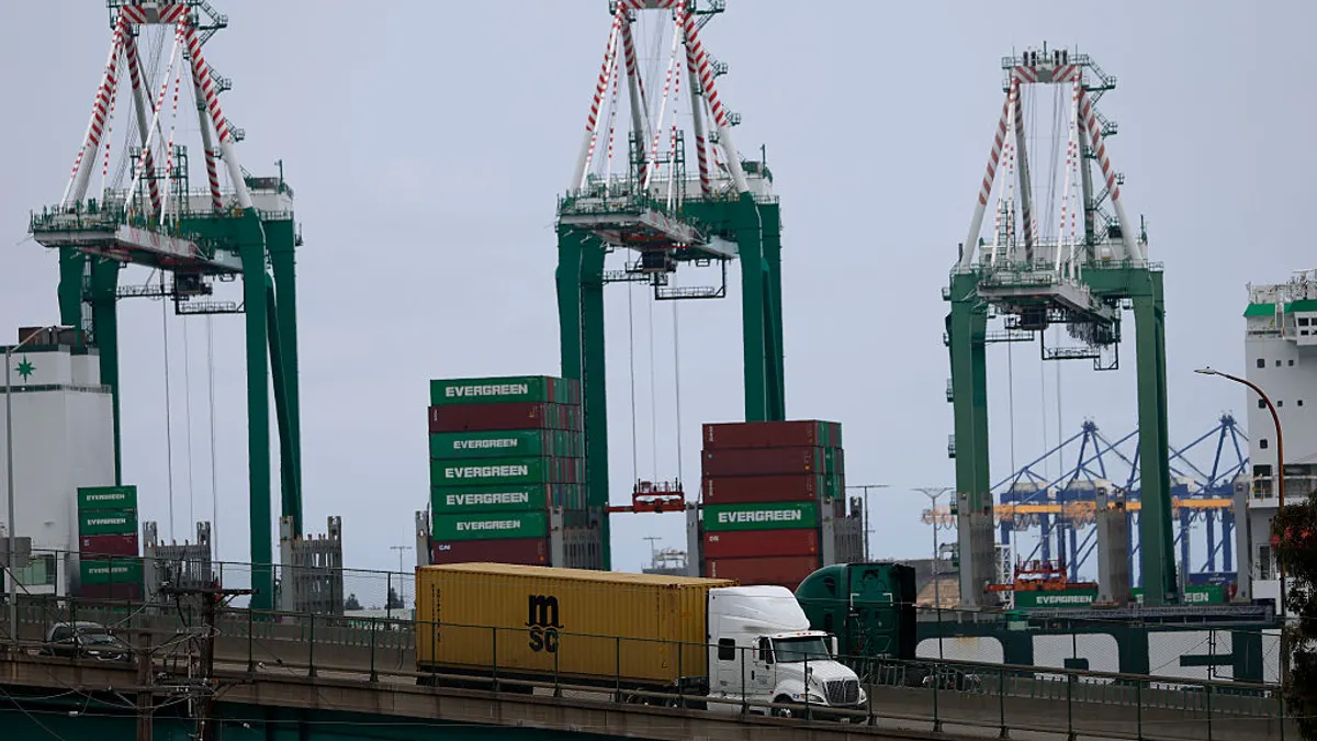 A truck drives over a bridge near a water port.