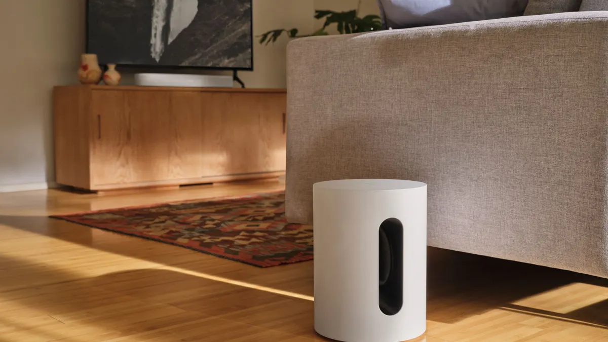 The Sonos Sub Mini on the floor of a living room.