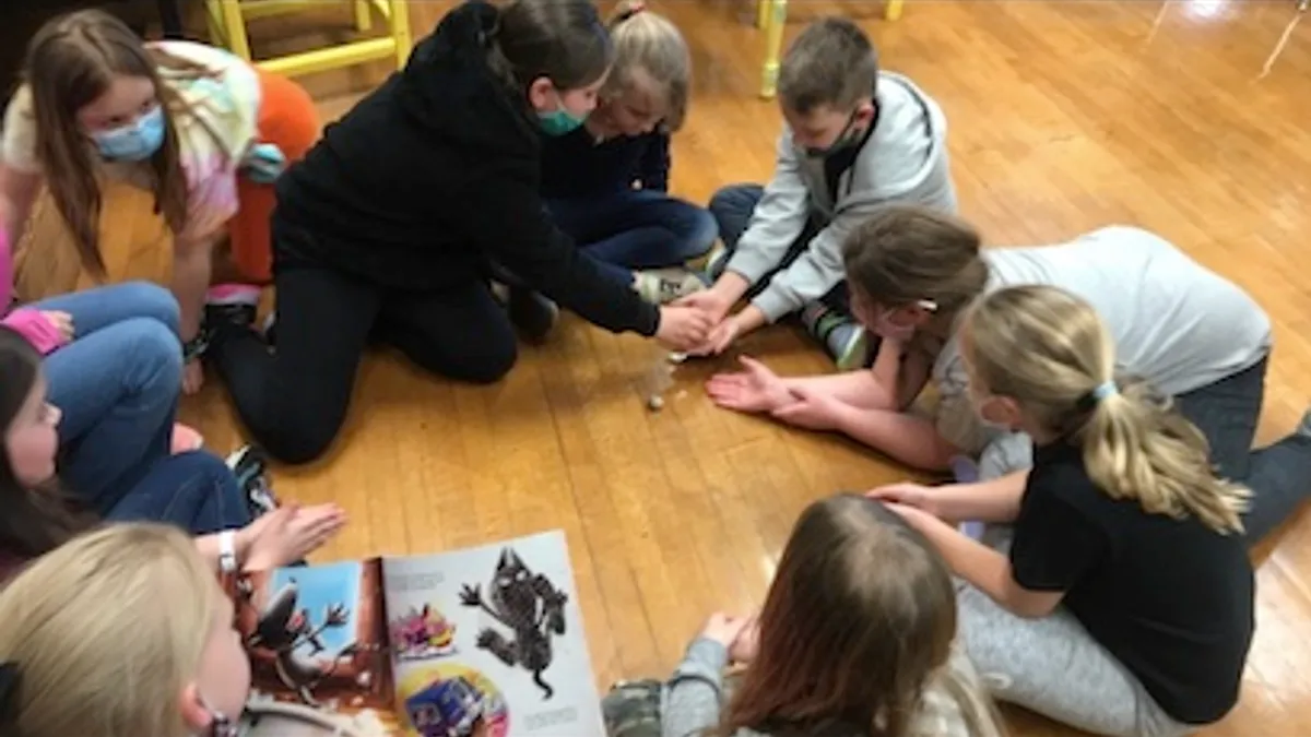 A reading interventionist in Carmi-White County CUSD 5 in Carmi, Illinois, lets students read to a hermit crab in February 2022.