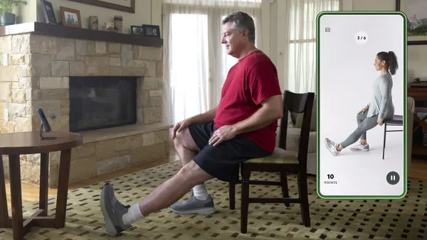 A patient doing leg exercises guided by a smartphone using Hinge Health.