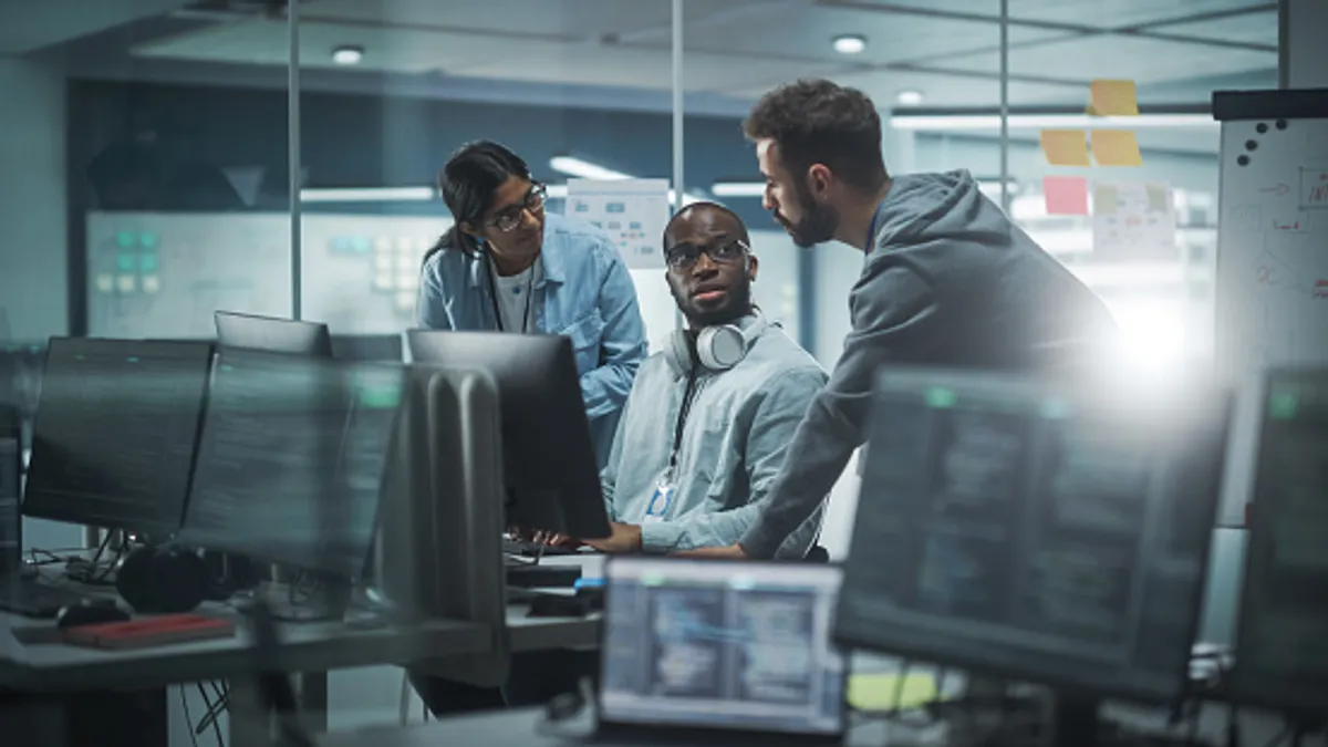 Group of professionals meeting in office around computers