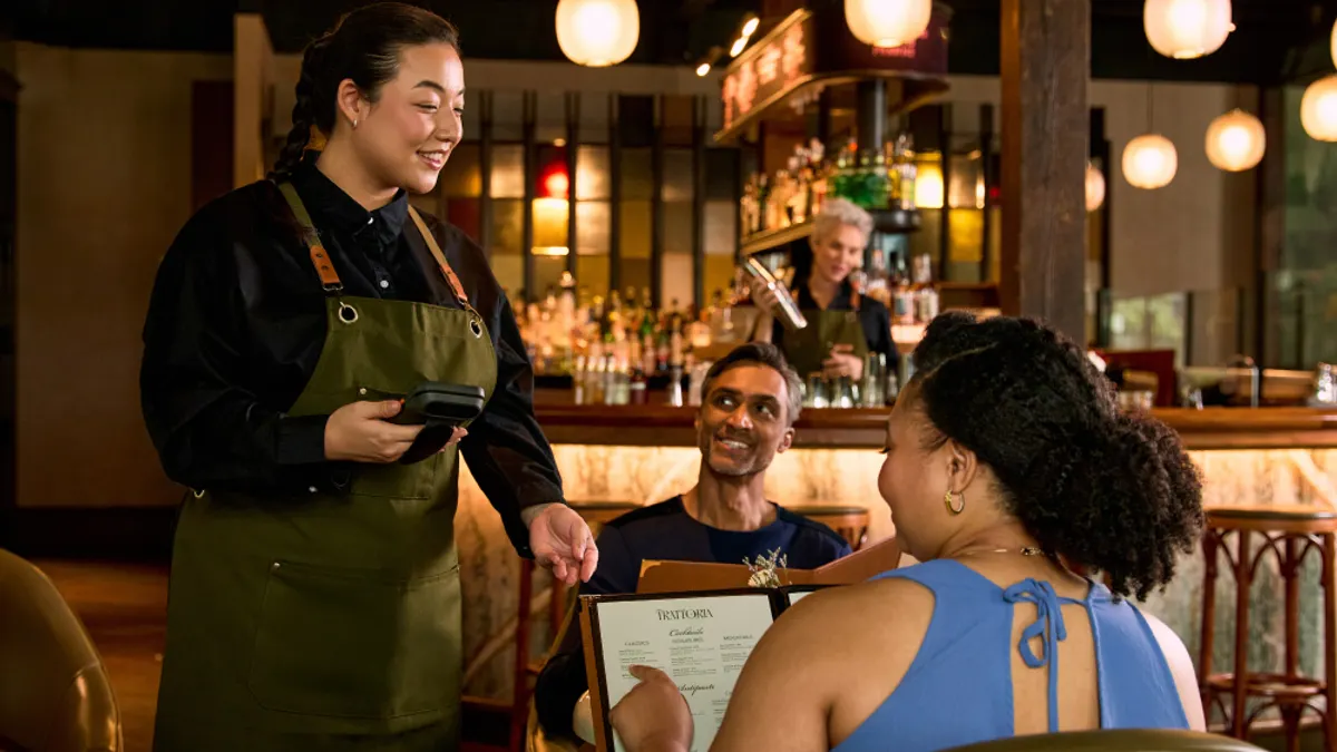 Server serving guests at a restaurant.