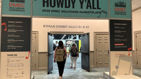 Signs for DMEC conference and people walking by