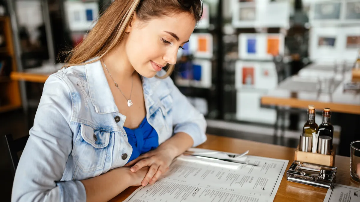 Brunette female glancing through menu