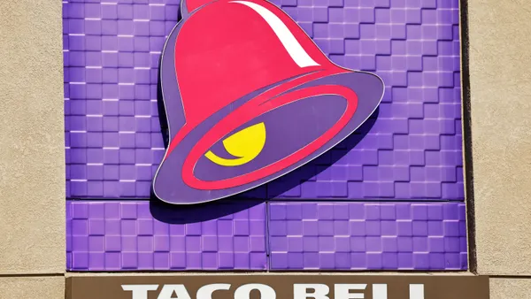A photograph of a purple Taco Bell logo on the side of a building.