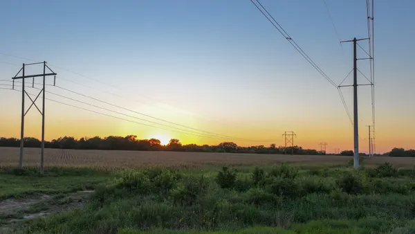 Electric transmission lines cross a field.