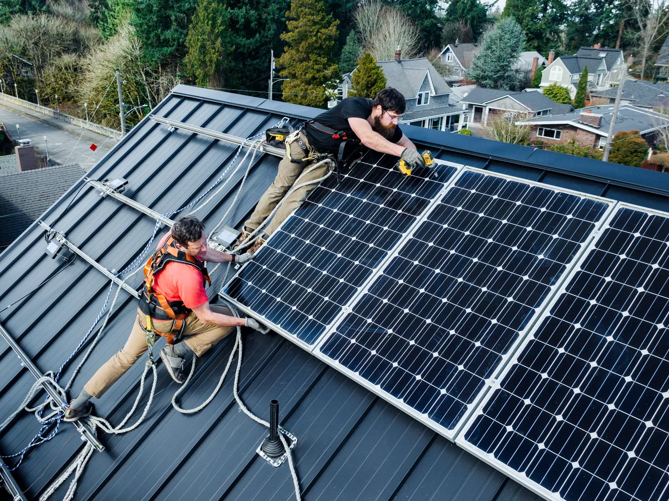 A solar crew installs panels on the roof of a house in Washington.