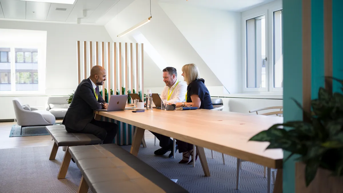 Employees sit around a table at an Adecco Group office.