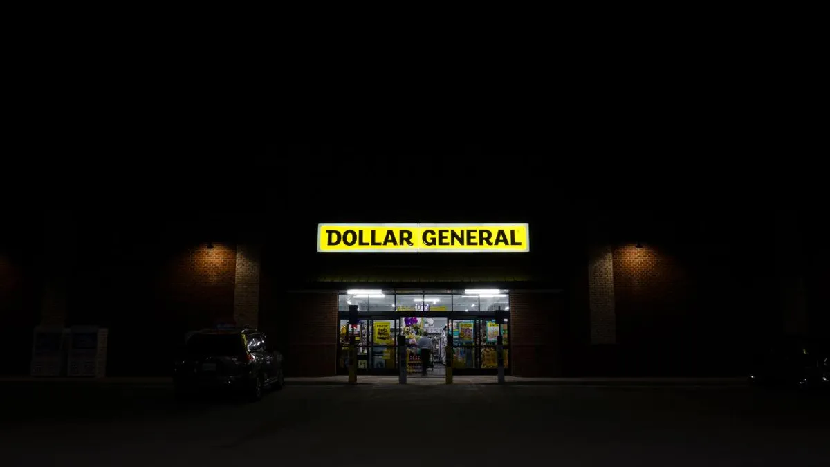 A Dollar General storefront at nighttime featuring the company's signature yellow and black sign