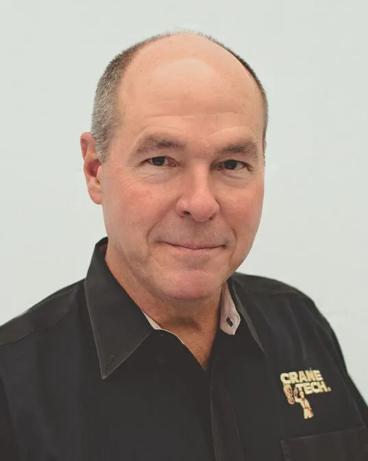 Headshot of a man with graying hair in a black collared shirt.