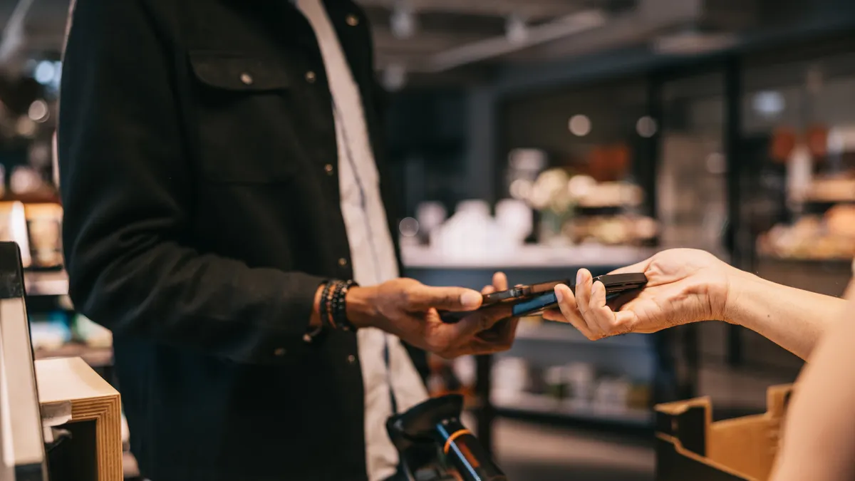 A male customer stands at the checkout counter of a local organic convenience store