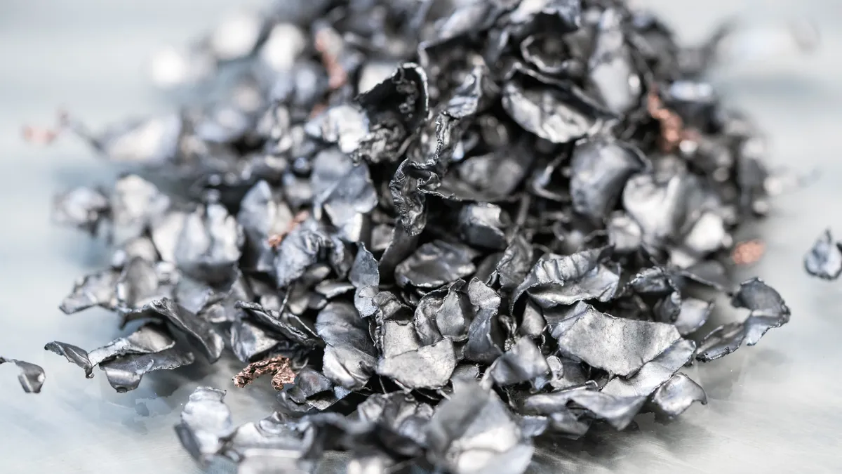 An upclose of a small pile of chopped up recycled metal laying on a white ground.