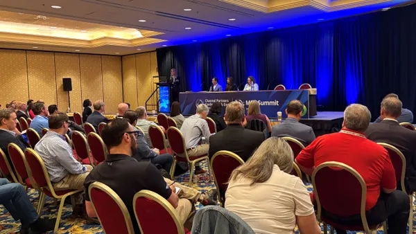 room of seated people watching a panel