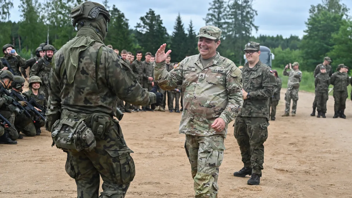 People in uniforms shake hands.