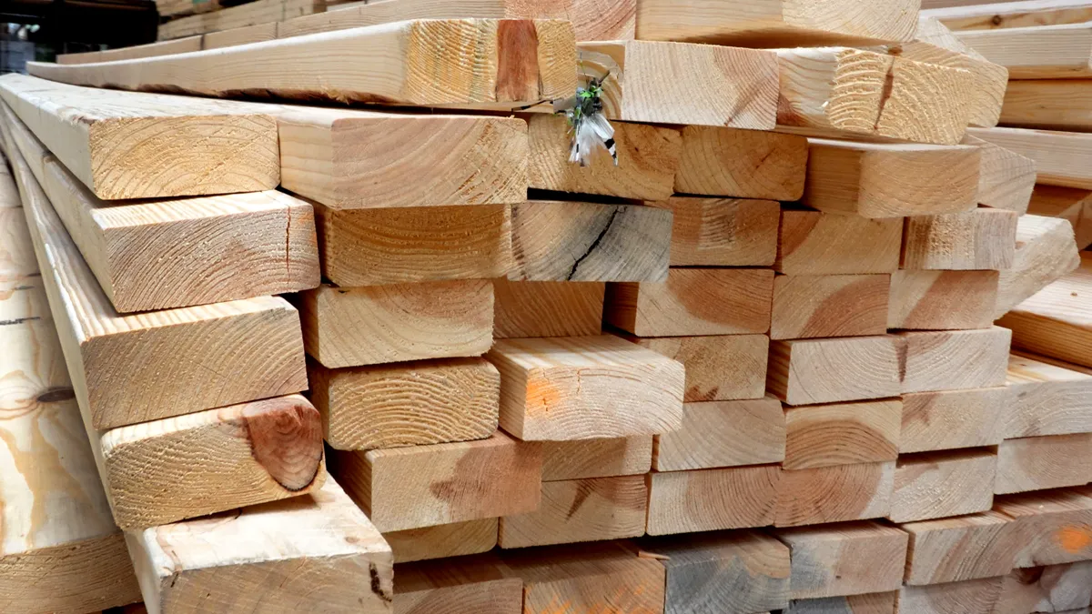 Lumber is stacked up at a home improvement store, being offered for sale.