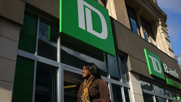 Woman stands under TD Bank sign.