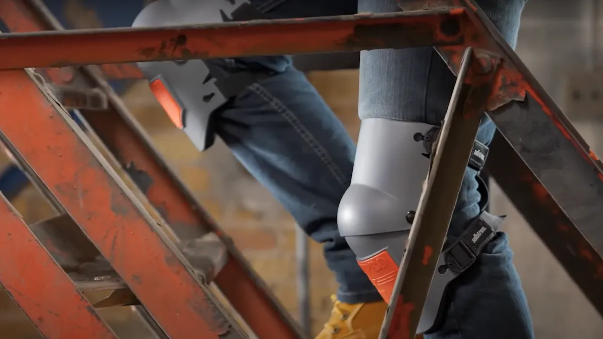 A person walks up stairs wearing knee pads.