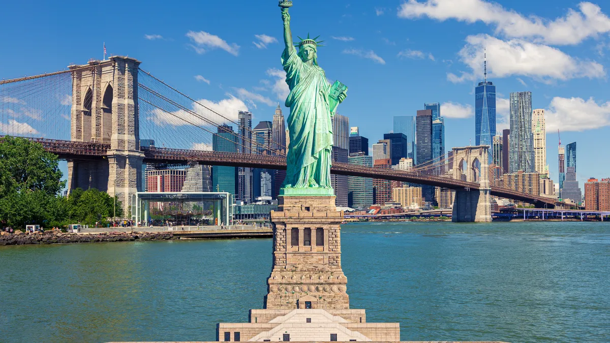 A view of the Statue of Liberty against the New York City skyline with a backdrop of the World Trade Center, Brooklyn Bridge and Manhattan high-rise buildings