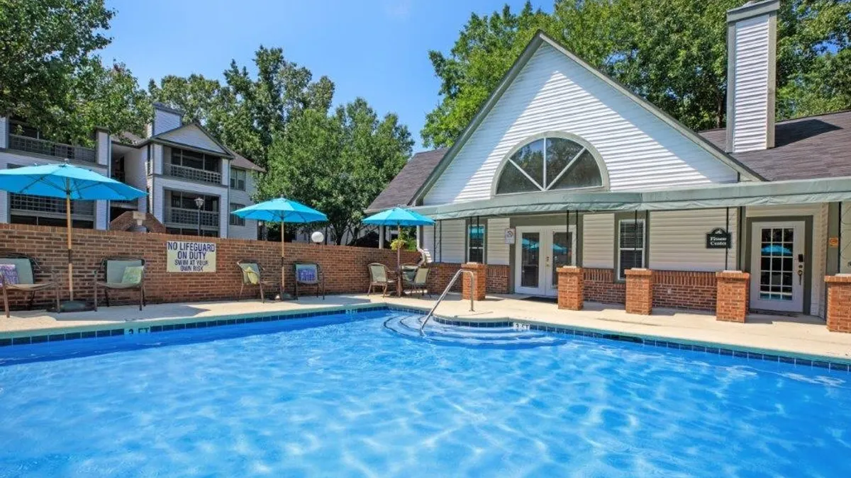 Pool with apartments and clubhouse in the background.