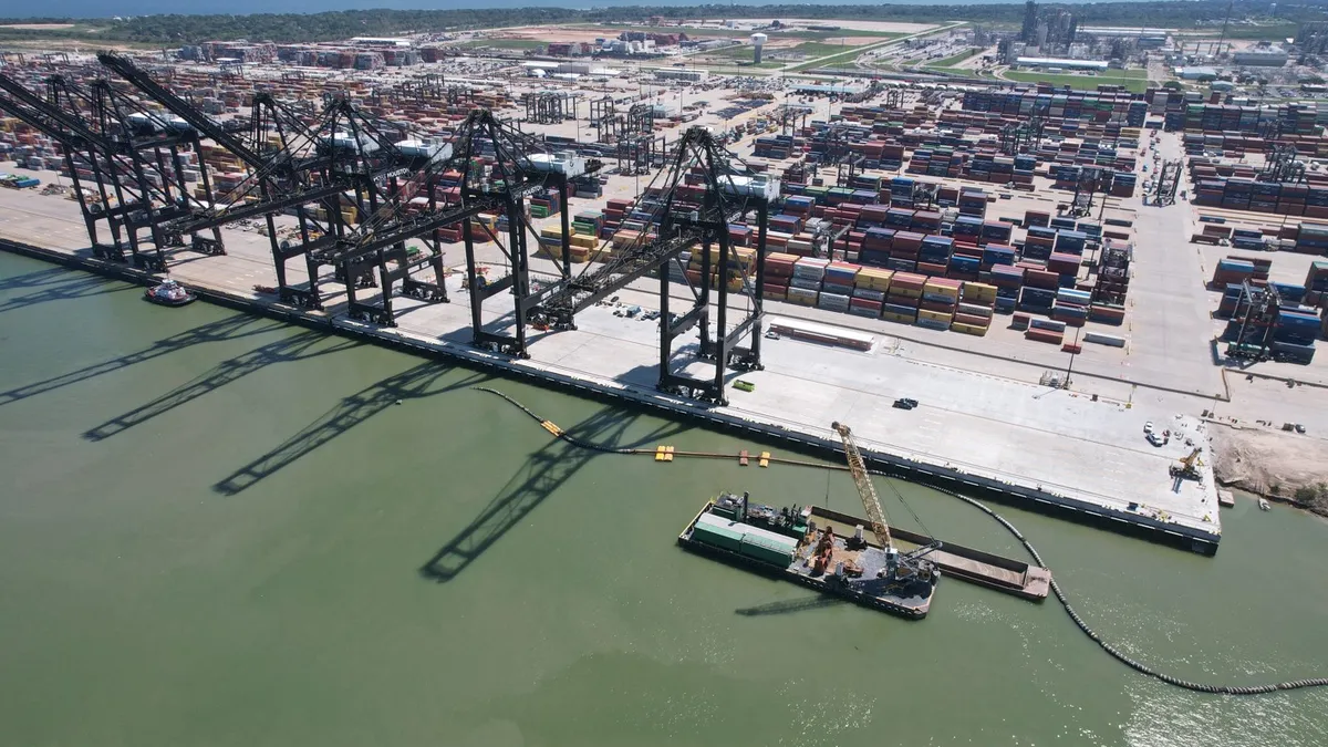 An overhead shot of a port with several docks for large ships. The water is an azure-y green.