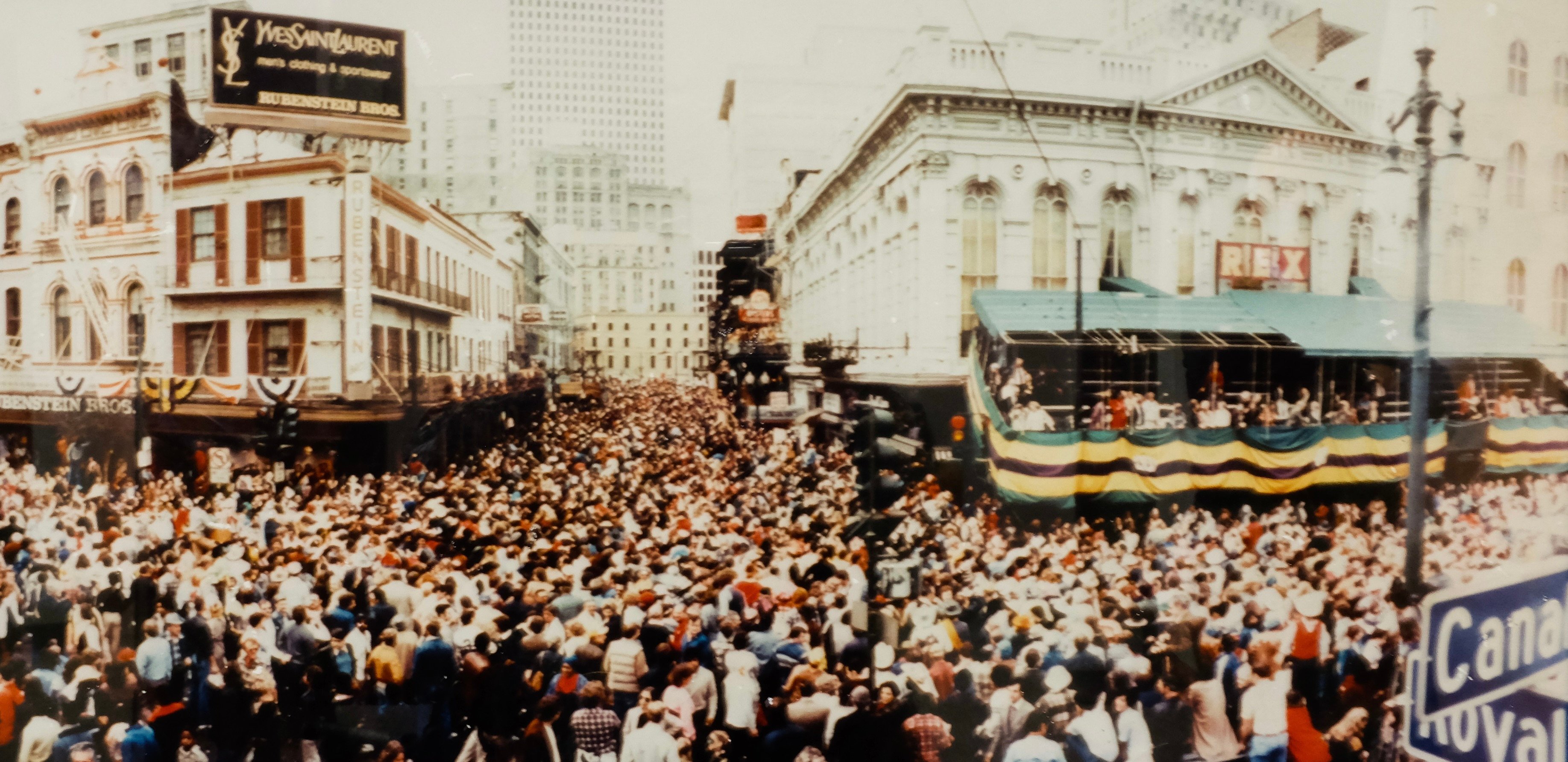 A crowd of people fills the streets in a photo of New Orleans during Mardi Gras.