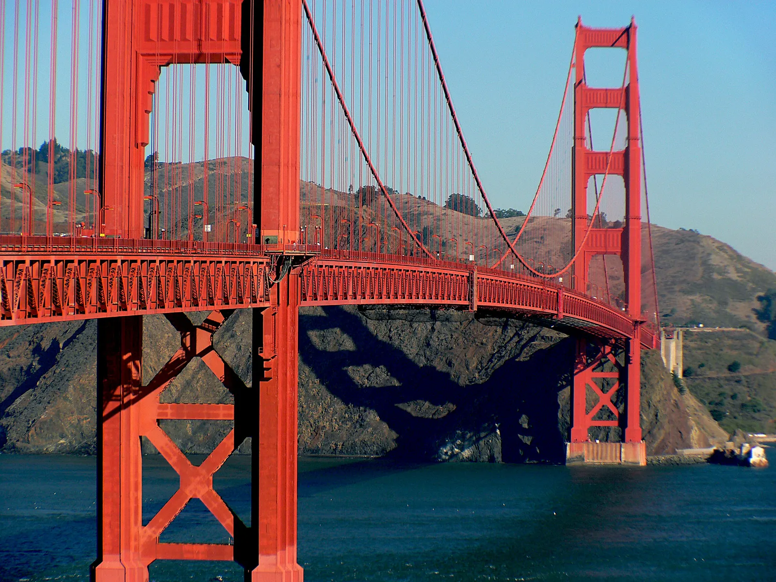 An elegant reddish orange span over a bright blue body of water.