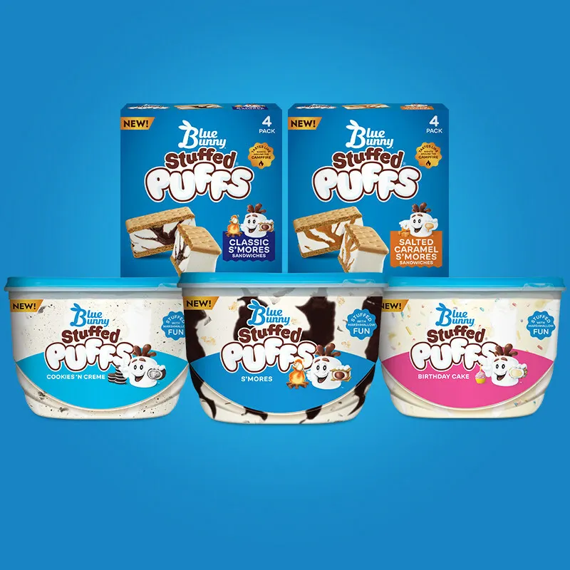 Three containers of Blue Bunny Stuffed Puffs ice cream are lined up on a blue background, with two boxes of Blue Bunny Stuffed Puffs Ice Cream Sandwiches stacked on top.