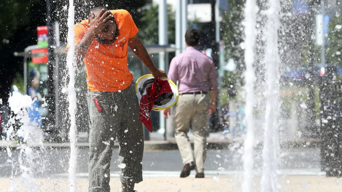 Construction workers uses water fountain during hot day