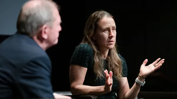 Anne Wojcicki sits in a chair speaking with Marcus Wallenberg during an event.