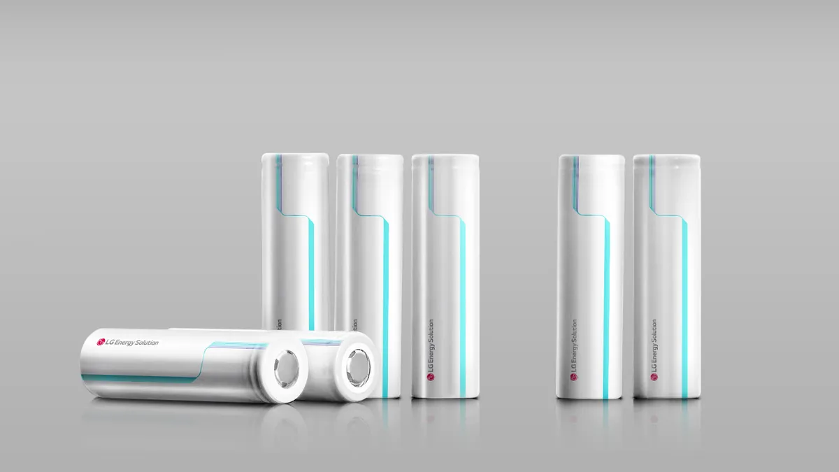 Two silver batteries lying horizontally on the left, with five silver batteries standing up vertically. All have neon blue-green line on them with the red LG Energy Solution logo on them.