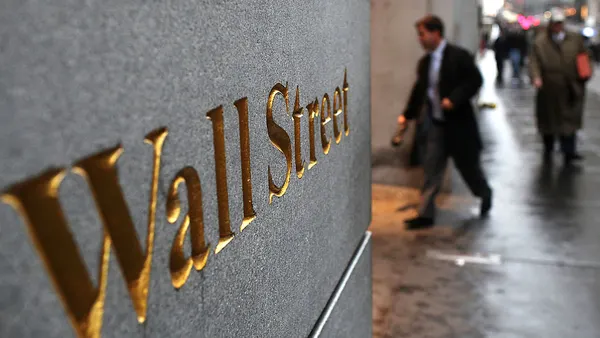 Engraving on a wall reads "wall street."