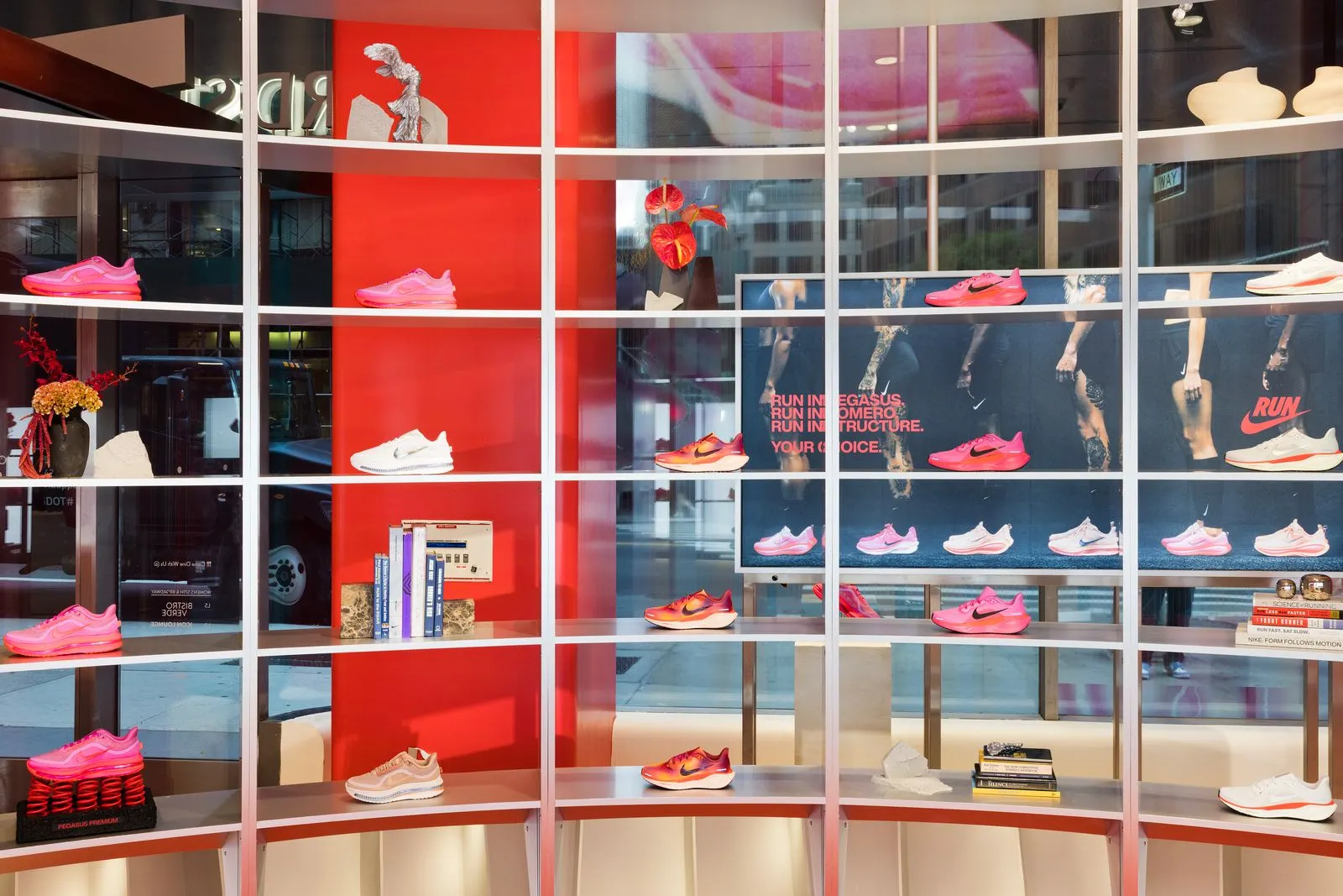 A wall of Nike running shoes in front of a window.