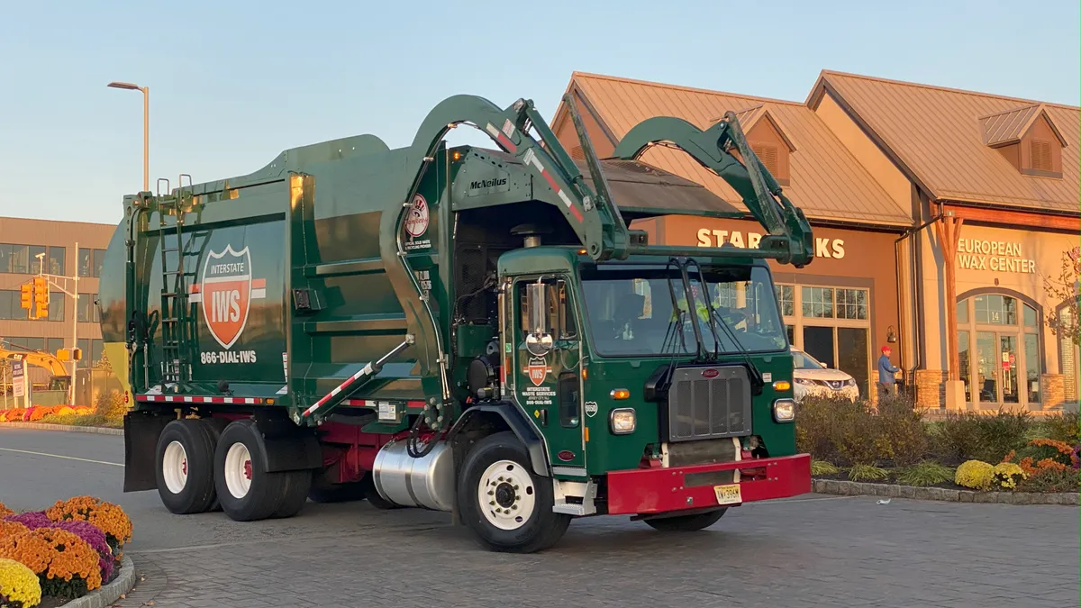 A garbage truck with Interstate Waste Services branding on the side