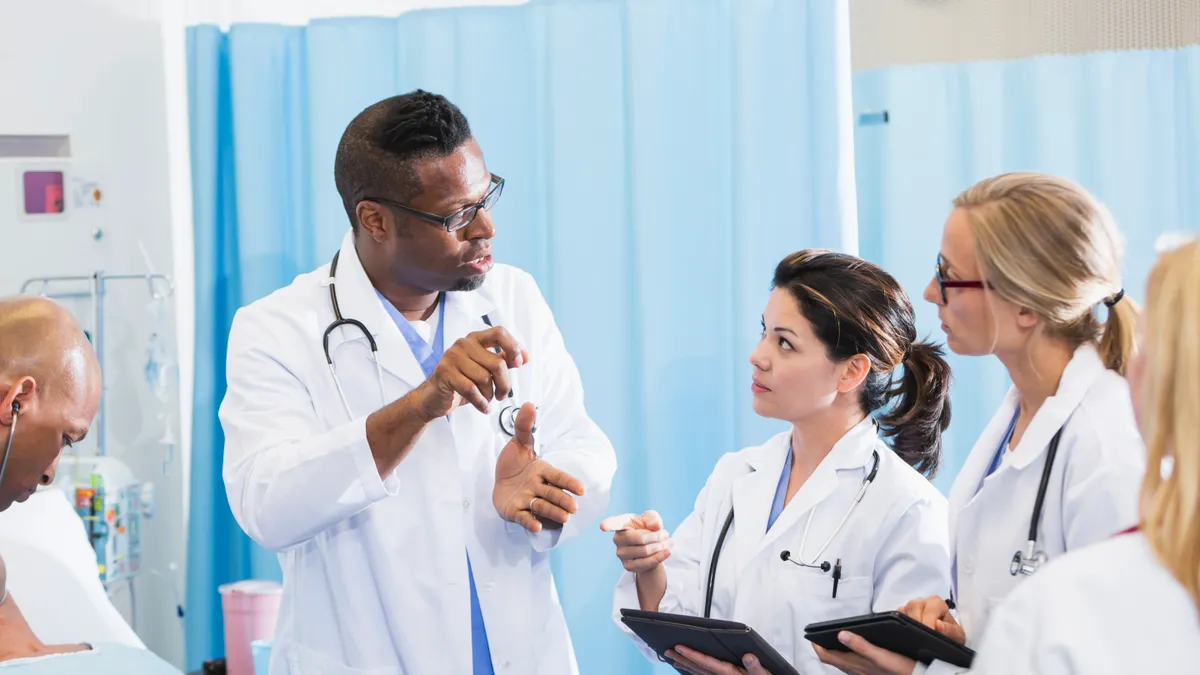 A senior teaching doctor instruction three medical students while on rotation.