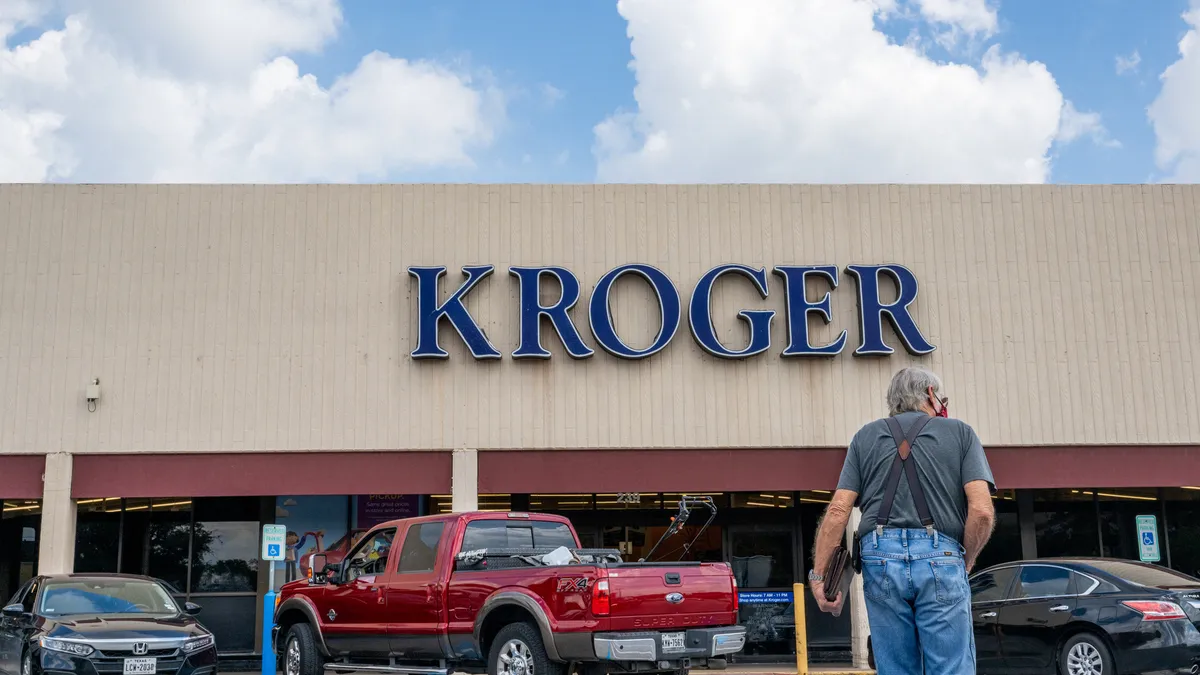 A customer walks into a Kroger grocery store.