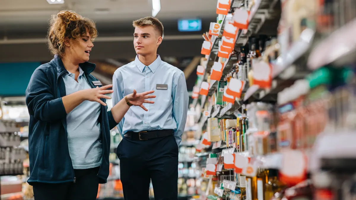 Store incharge training young worker. Supermarket manager giving training to a trainee.